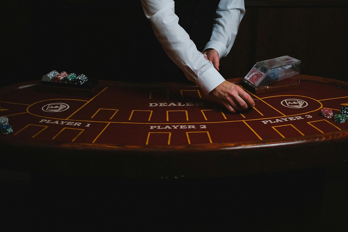 Mesa de blackjack en un casino español con crupier repartiendo cartas y fichas de apuesta